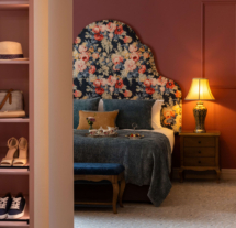 Cosy hotel room with a floral headboard, inviting bed, and warm lighting for relaxation.