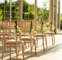 Sunlit event space with elegant chairs at Fernhill House Hotel, ready for a gathering.