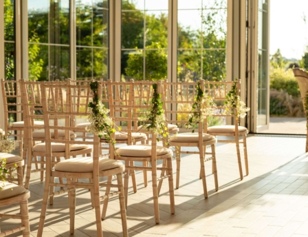 Sunlit event space with elegant chairs at Fernhill House Hotel, ready for a gathering.