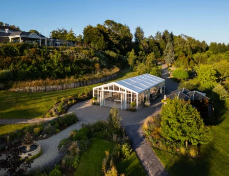 A serene garden setting with a glasshouse under clear blue skies at Fernhill House Hotel.