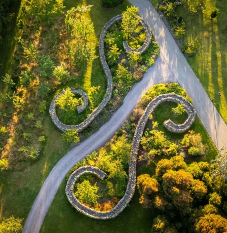 A serene aerial view of Fernhill House Hotel gardens with winding stone pathways and lush greenery.