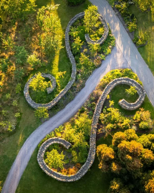 A serene aerial view of Fernhill House Hotel gardens with winding stone pathways and lush greenery.