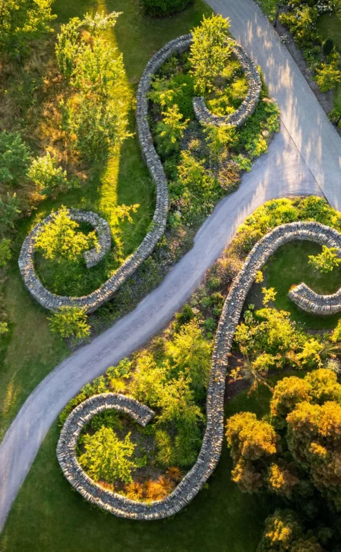 A serene aerial view of Fernhill House Hotel gardens with winding stone pathways and lush greenery.