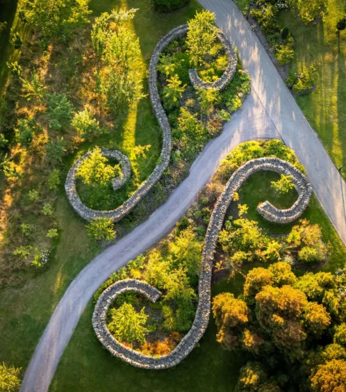 A serene aerial view of Fernhill House Hotel gardens with winding stone pathways and lush greenery.