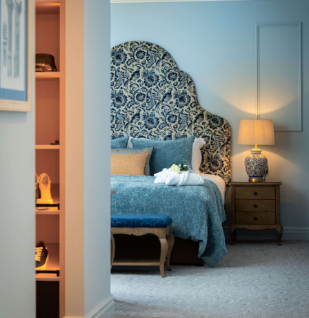 Cosy hotel suite with elegant decor and soft lighting, featuring a comfortable bed and plush furnishings.