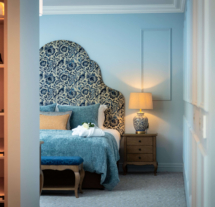 Elegant hotel room with ornate headboard and warm lighting, creating a cosy atmosphere.