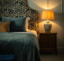 Elegant hotel room with soft lighting and stylish decor, featuring a beautifully adorned bed.
