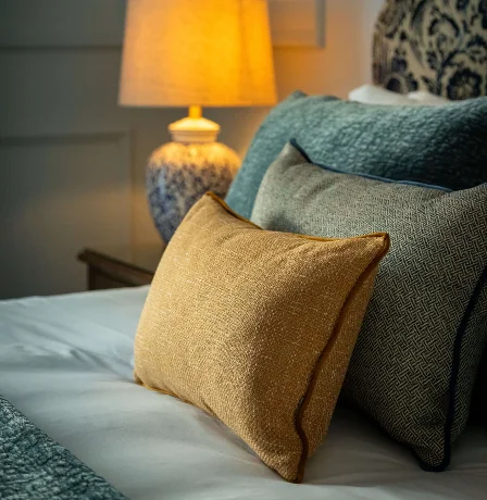 Cosy hotel room with soft lighting and comfortable cushions.