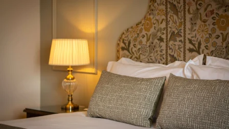 Cosy, elegant hotel room with a warm glow from a bedside lamp.
