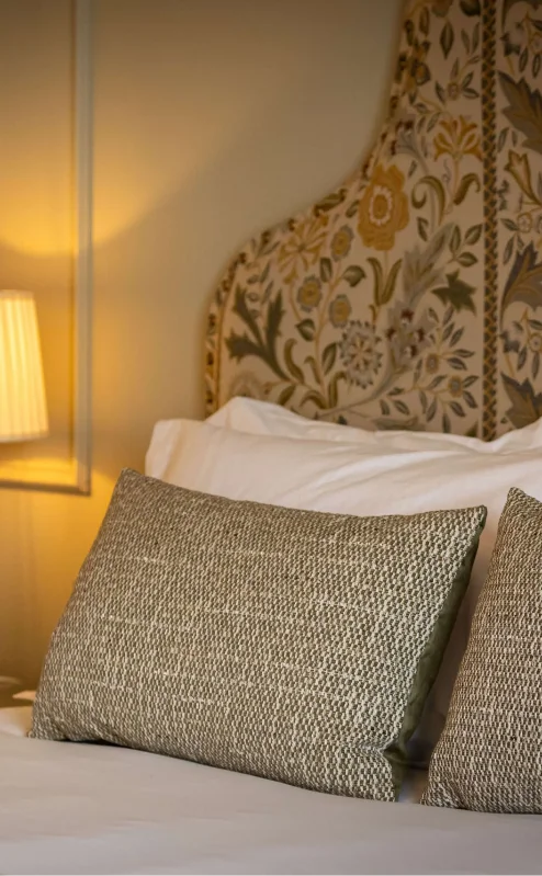 Cosy, elegant hotel room with a warm glow from a bedside lamp.
