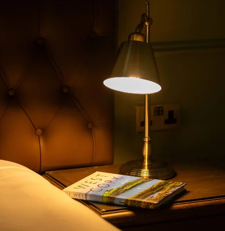 Cosy hotel room with lamp lighting and West Cork book.