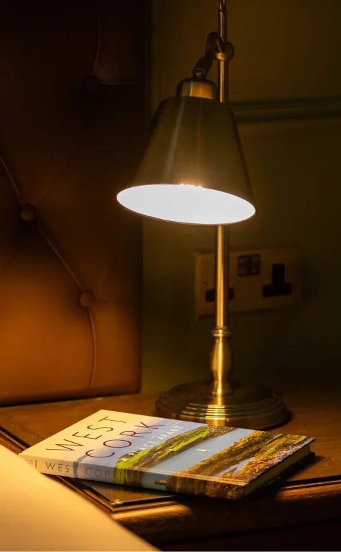 Cosy hotel room with lamp lighting and West Cork book.
