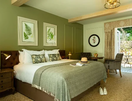 Cosy hotel room with double bed and view of a private garden patio.