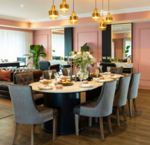 Elegant dining area with round table, plush chairs, and warm lighting at Fernhill House Hotel.