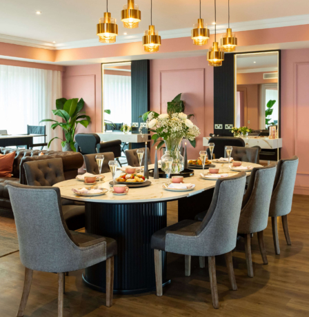 Elegant dining area with round table, plush chairs, and warm lighting at Fernhill House Hotel.