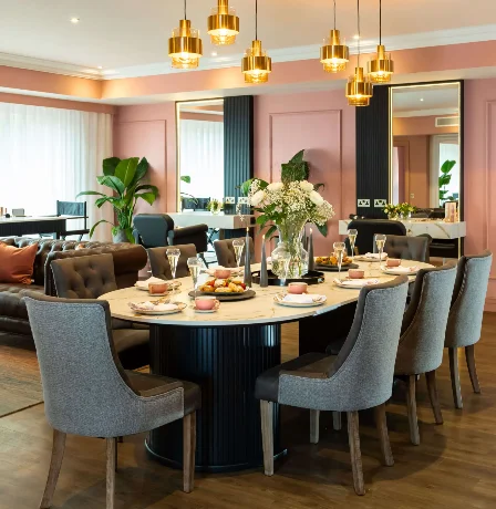 Elegant dining room in Fernhill House Hotel with round table, inviting decor, and warm lighting.
