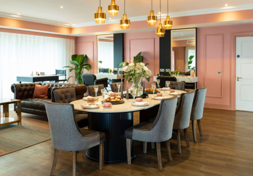 Elegant dining area with round table, plush chairs, and warm lighting at Fernhill House Hotel.