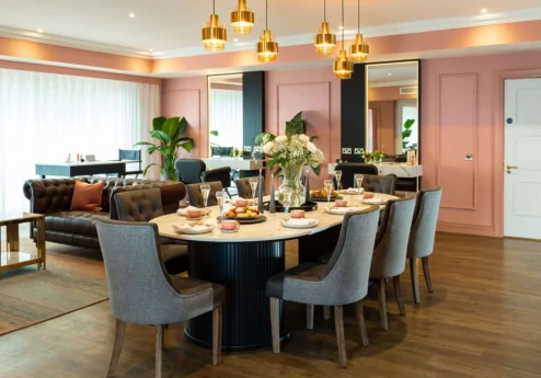 Elegant dining room in Fernhill House Hotel with round table, inviting decor, and warm lighting.