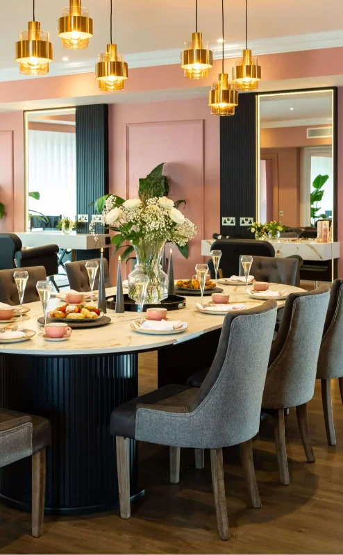 Elegant dining room in Fernhill House Hotel with round table, inviting decor, and warm lighting.