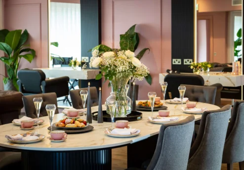 Elegant dining table set with flowers and glasses in a cosy hotel restaurant.
