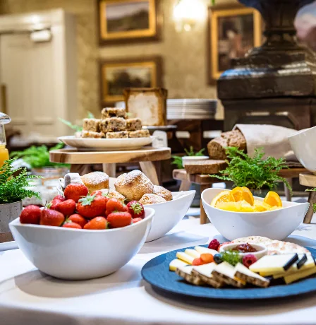 Fresh fruit and cheese spread on elegant dining table in Fernhill House Hotel.