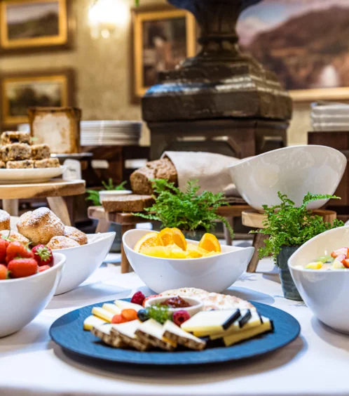 Fresh fruit and cheese spread on elegant dining table in Fernhill House Hotel.