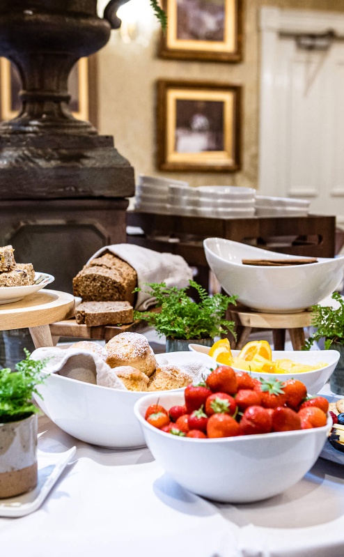 A family breakfast buffet at Fernhill House Hotel with fresh fruit, pastries, and juice.