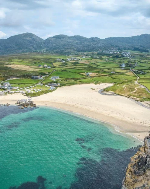Aerial view of lush countryside with beaches and mountains.
