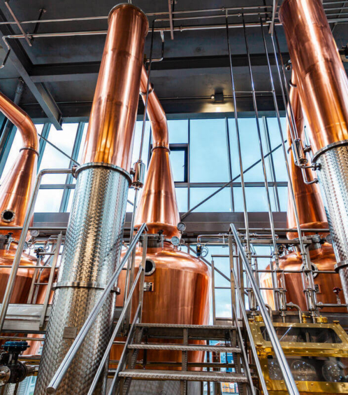 Family exploring distillery with copper vats at Fernhill House Hotel.