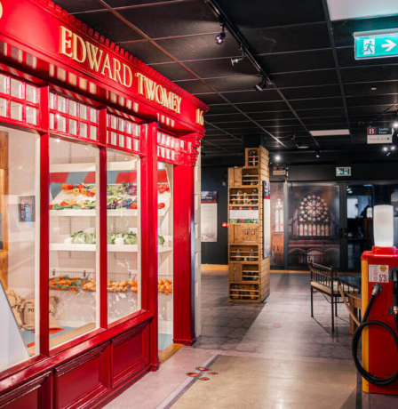 A family explores a hotel hallway with vibrant red storefront display.