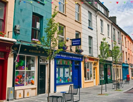 Colourful street with vibrant shopfronts and festive bunting, Fernhill vicinity.