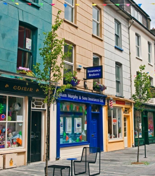 Colourful street with shops and bunting on a sunny day.