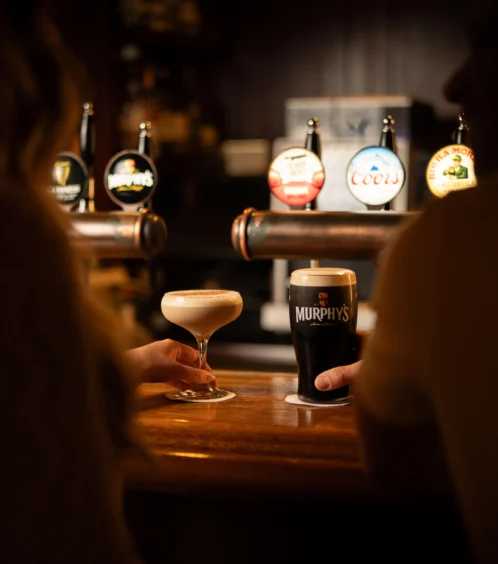Couple enjoying drinks at Fernhill House Hotel bar.