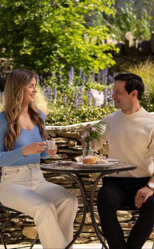 Couple enjoying tea in a lush Fernhill House Hotel garden