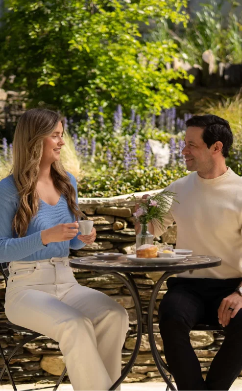 Couple enjoying coffee at a garden patio in Fernhill House Hotel.