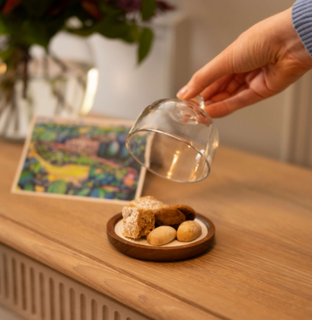Guest unveiling treats on a table with flowers and artwork at Fernhill House Hotel.