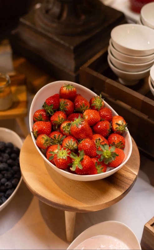 Delicious breakfast spread with fresh berries and pastries in a cosy, inviting hotel setting.