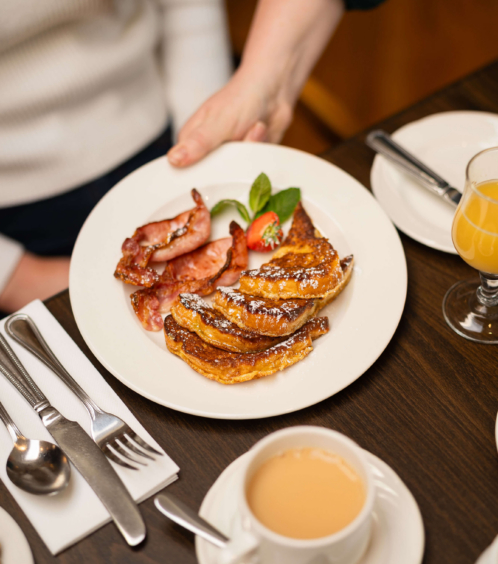 Cosy breakfast at Fernhill House Hotel with tea, French toast, and bacon.