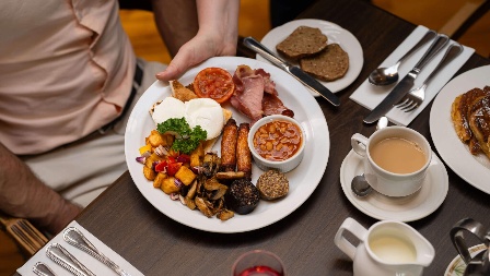 Family enjoying hearty breakfast at Fernhill House Hotel with traditional Irish dishes.