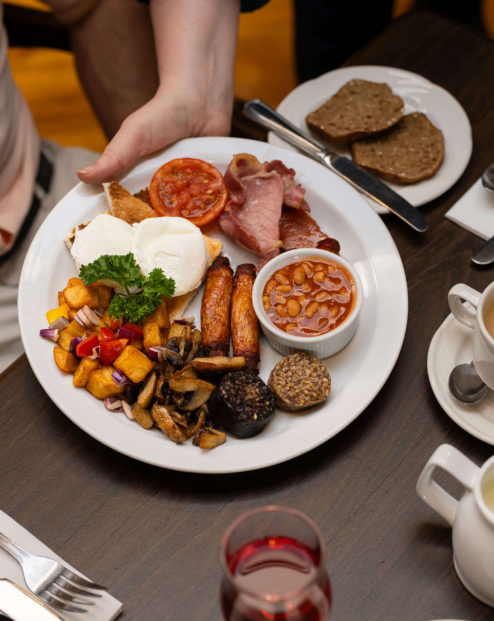 Family enjoying hearty breakfast at Fernhill House Hotel with traditional Irish dishes.