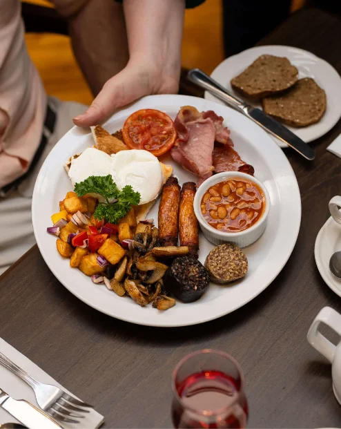 A family enjoys a hearty breakfast at Fernhill House Hotel's cosy dining area.