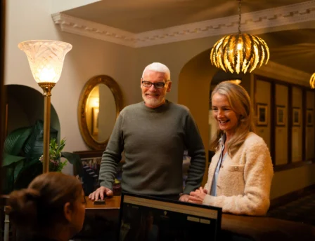A couple checks in at Fernhill House Hotel's inviting, warmly-lit reception area.