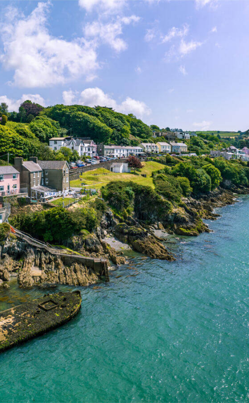 Coastal view of Glandore, West Cork with lush greenery and people enjoying the sunny day.