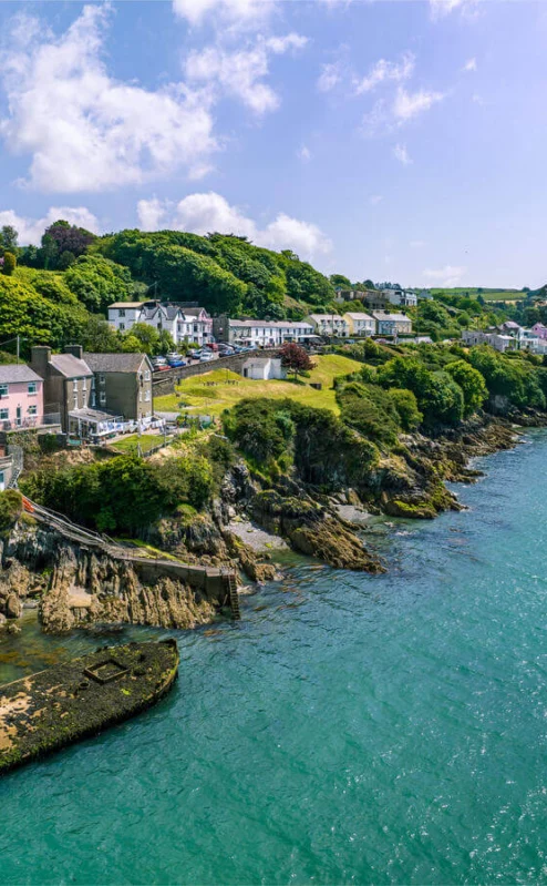 Scenic view of Fernhill House Hotel by the vibrant Irish coastline, families enjoying the sea.