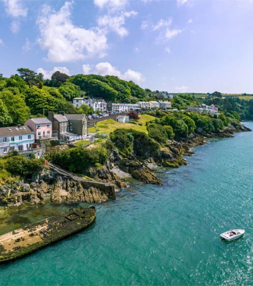 Coastal village view near Fernhill House Hotel with lush greenery and tranquil blue waters.