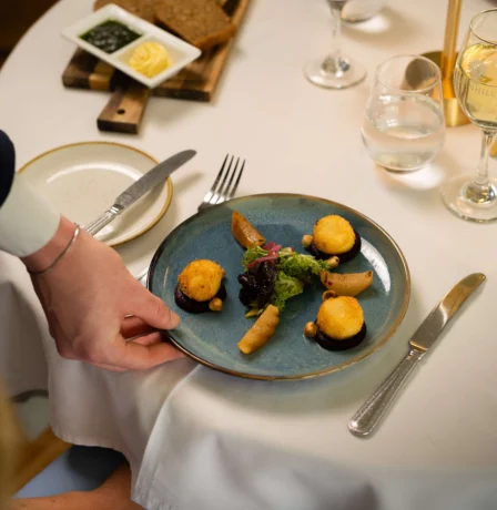 Elegant dining setup with gourmet appetisers at Fernhill House Hotel.