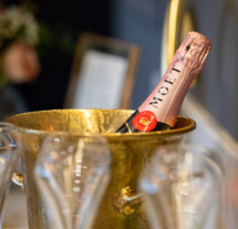 Chilled champagne bottle in a golden ice bucket at elegant celebration setting.