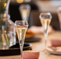 Elegant dining table with champagne flutes, pink bowls, and floral centrepiece at Fernhill House Hotel.