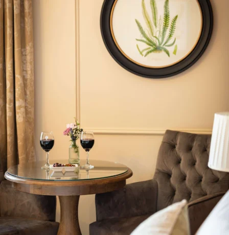 Cosy hotel room with a table, wine glasses, and elegant decor