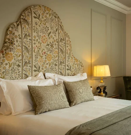 Elegant hotel room with a cosy bed, soft lighting, and a warm atmosphere.